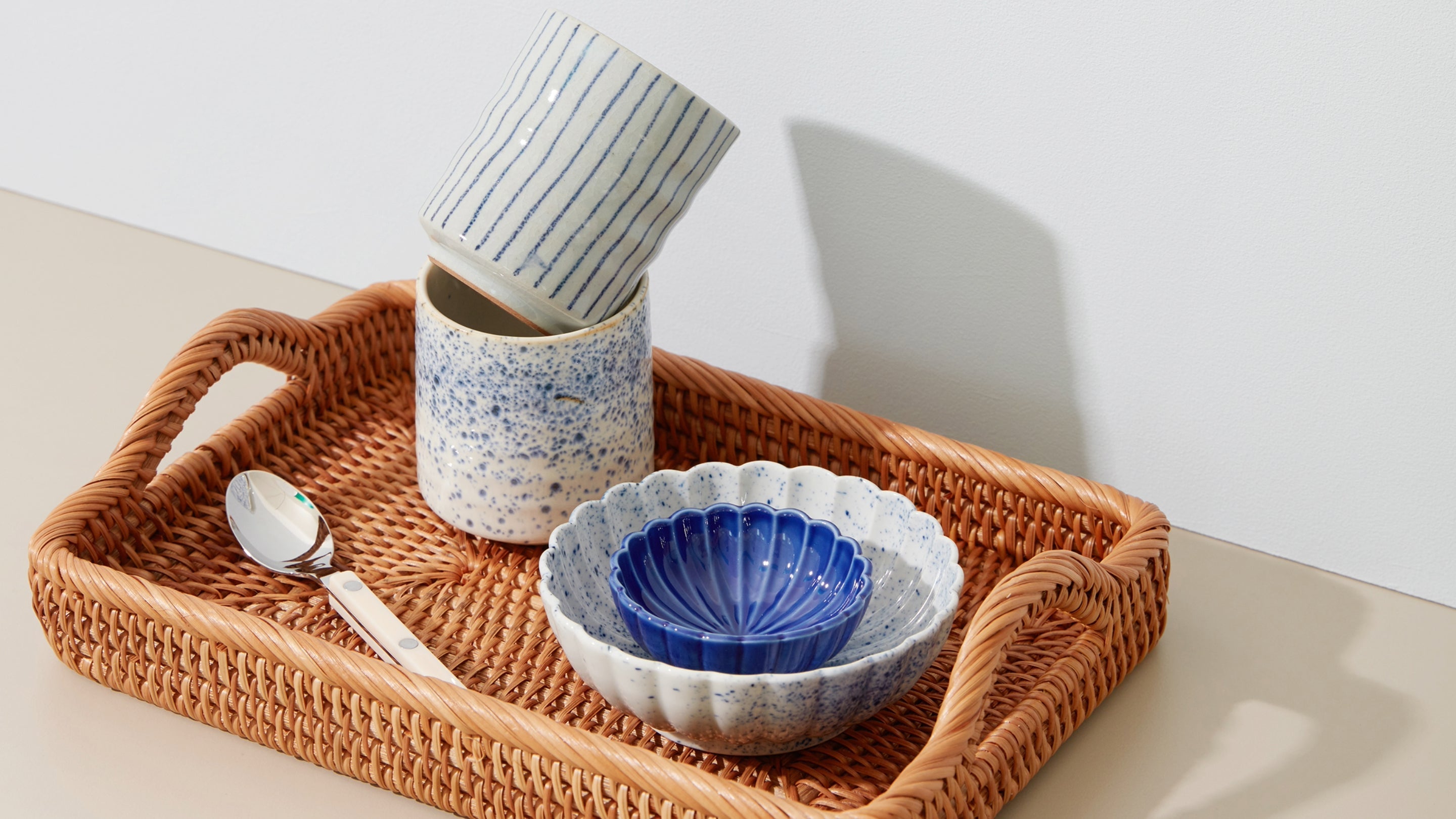 Japansk design: japansk keramik på rattanbakke – stribet kop, sprættet bæger og blå muslingeskåle – Studio Hafnia