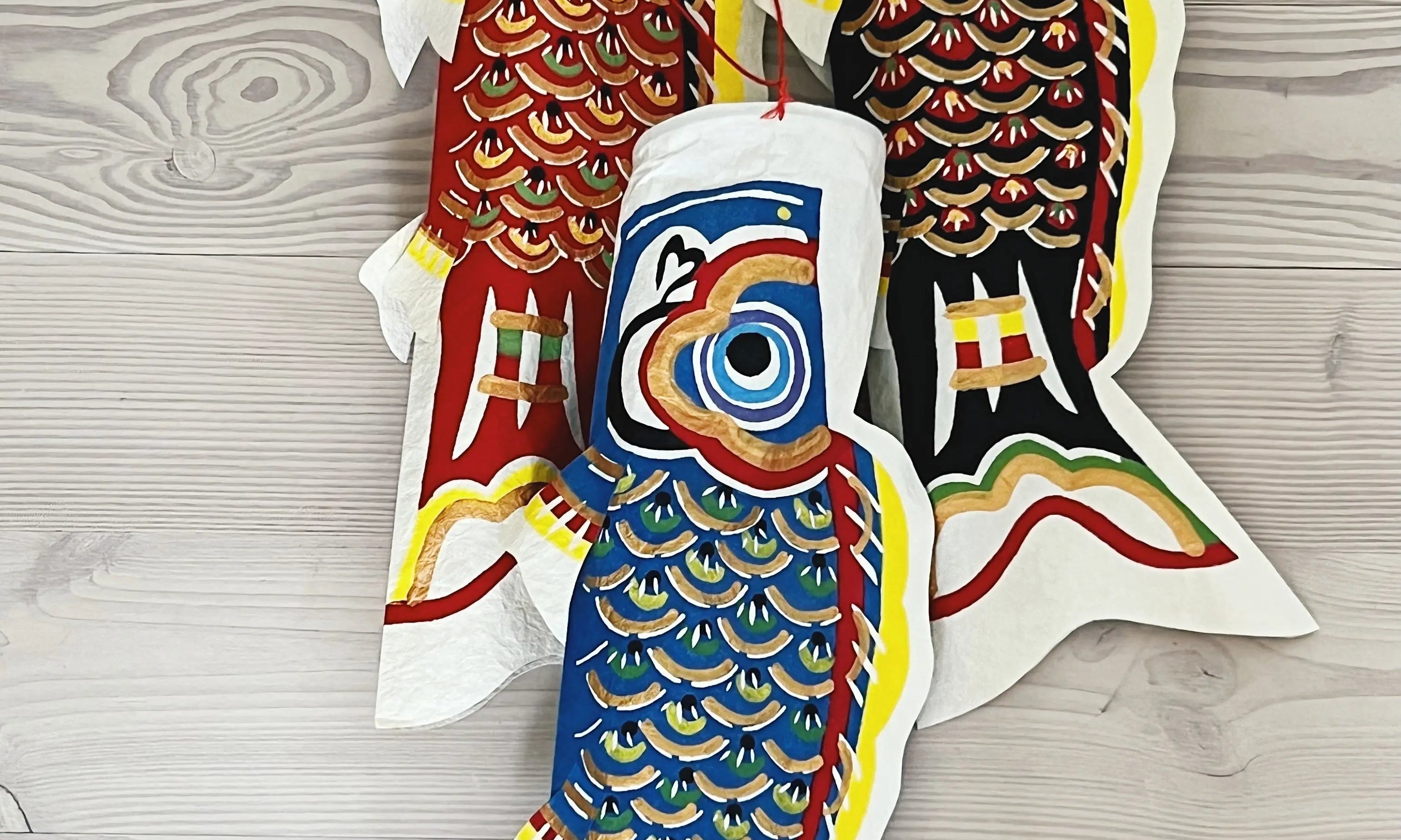 Three hand-painted Koi Koinobori fish in washi paper – red, blue, and black Japanese decorative hangings symbolizing strength, luck, and family.