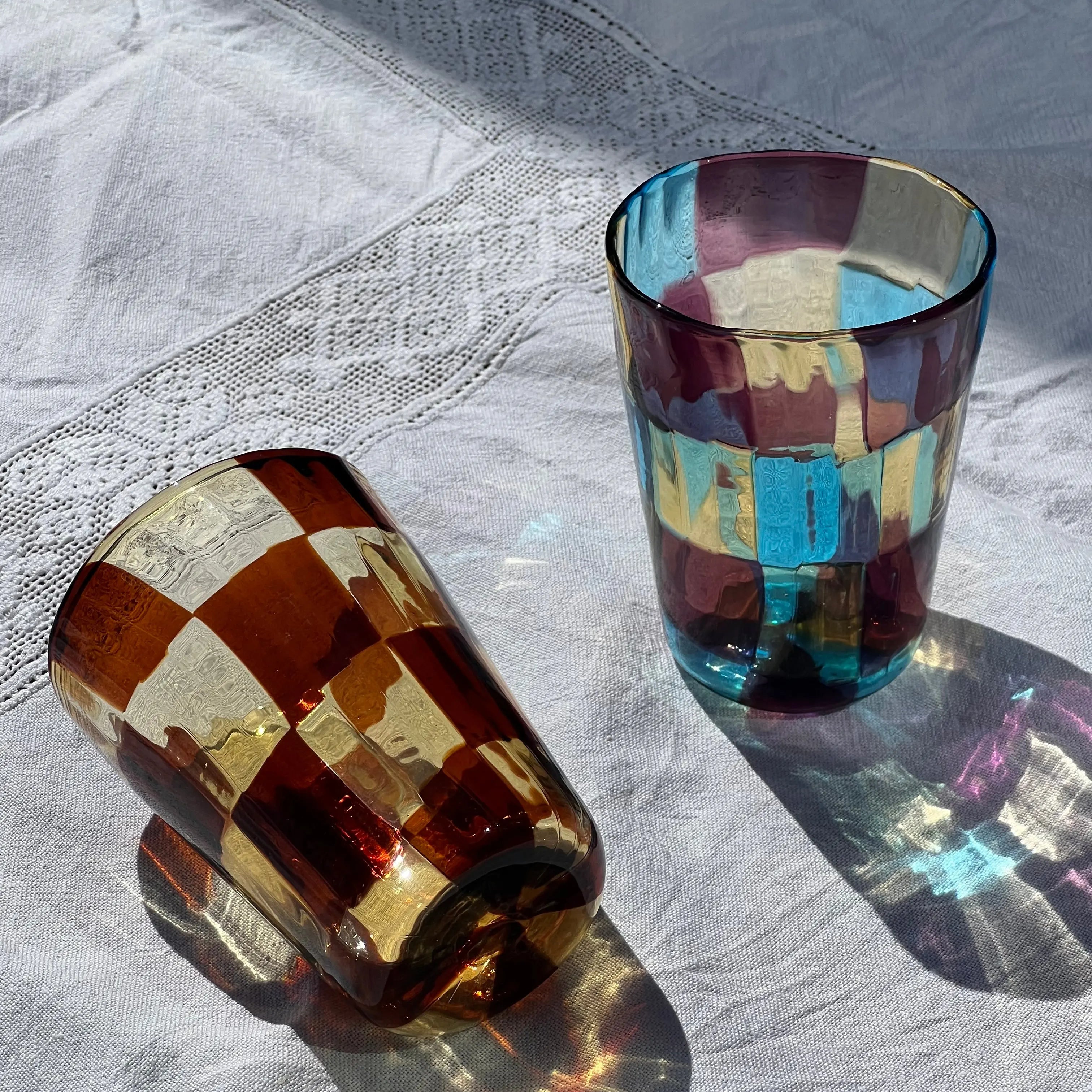 Set of Murano drinking glasses with checker pattern in multicolor design – unique Italian glassware for table and kitchen.