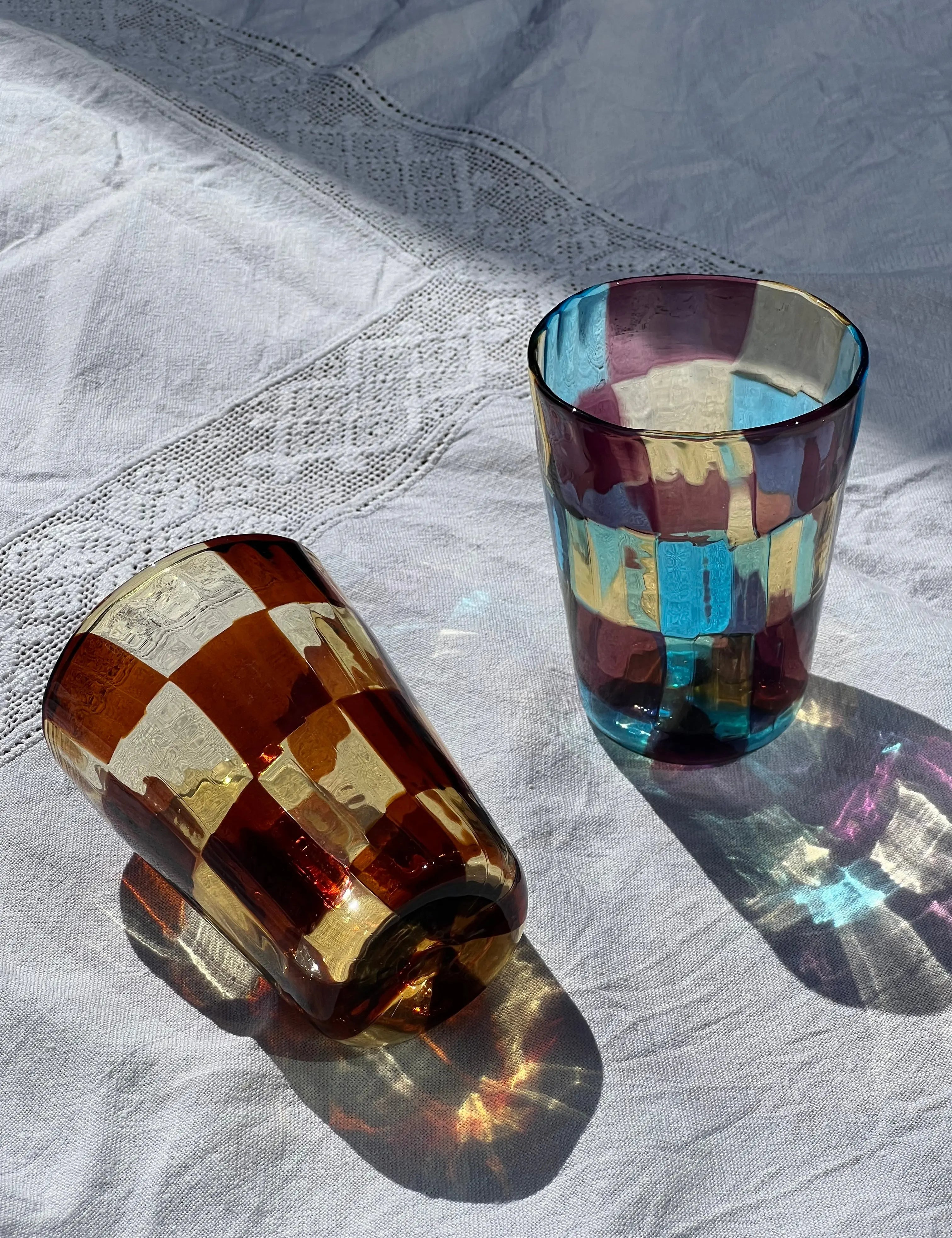 Set of Murano drinking glasses with checker pattern in multicolor design – unique Italian glassware for table and kitchen.