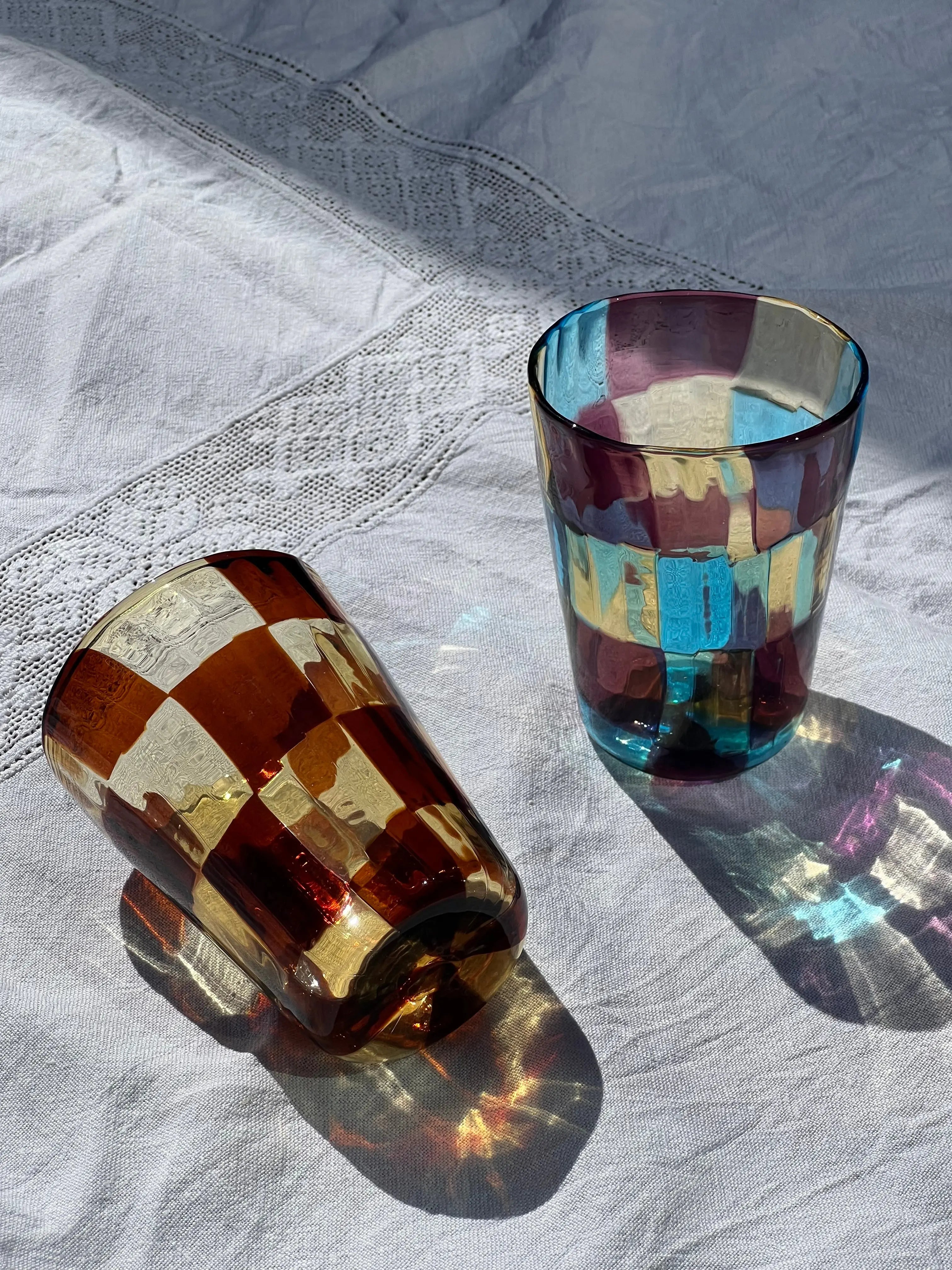Set of Murano drinking glasses with checker pattern in multicolor design – unique Italian glassware for table and kitchen.