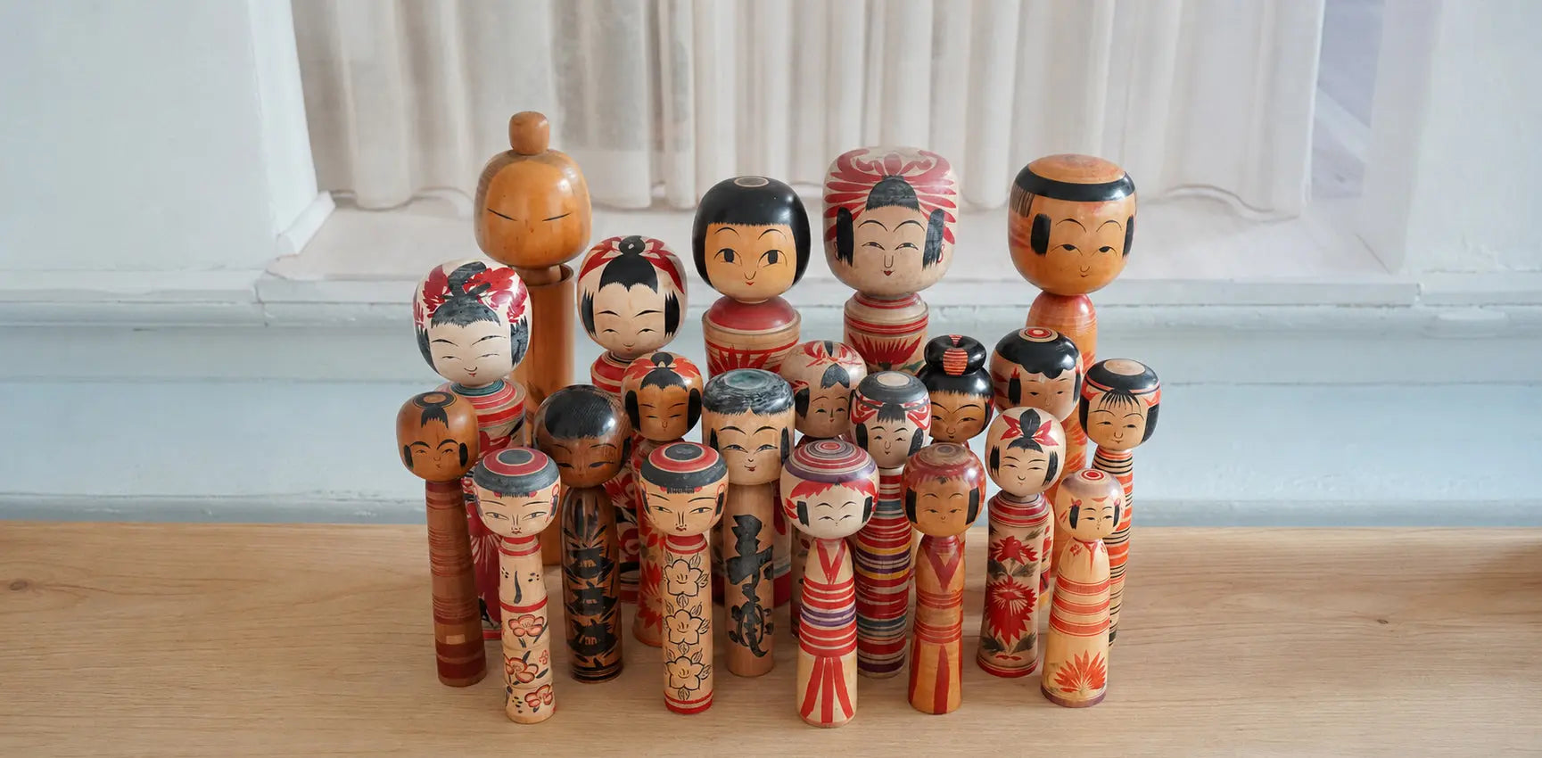Collection of vintage Japanese Kokeshi dolls in different sizes and designs – traditional handcrafted wooden dolls symbolizing culture and artistry.