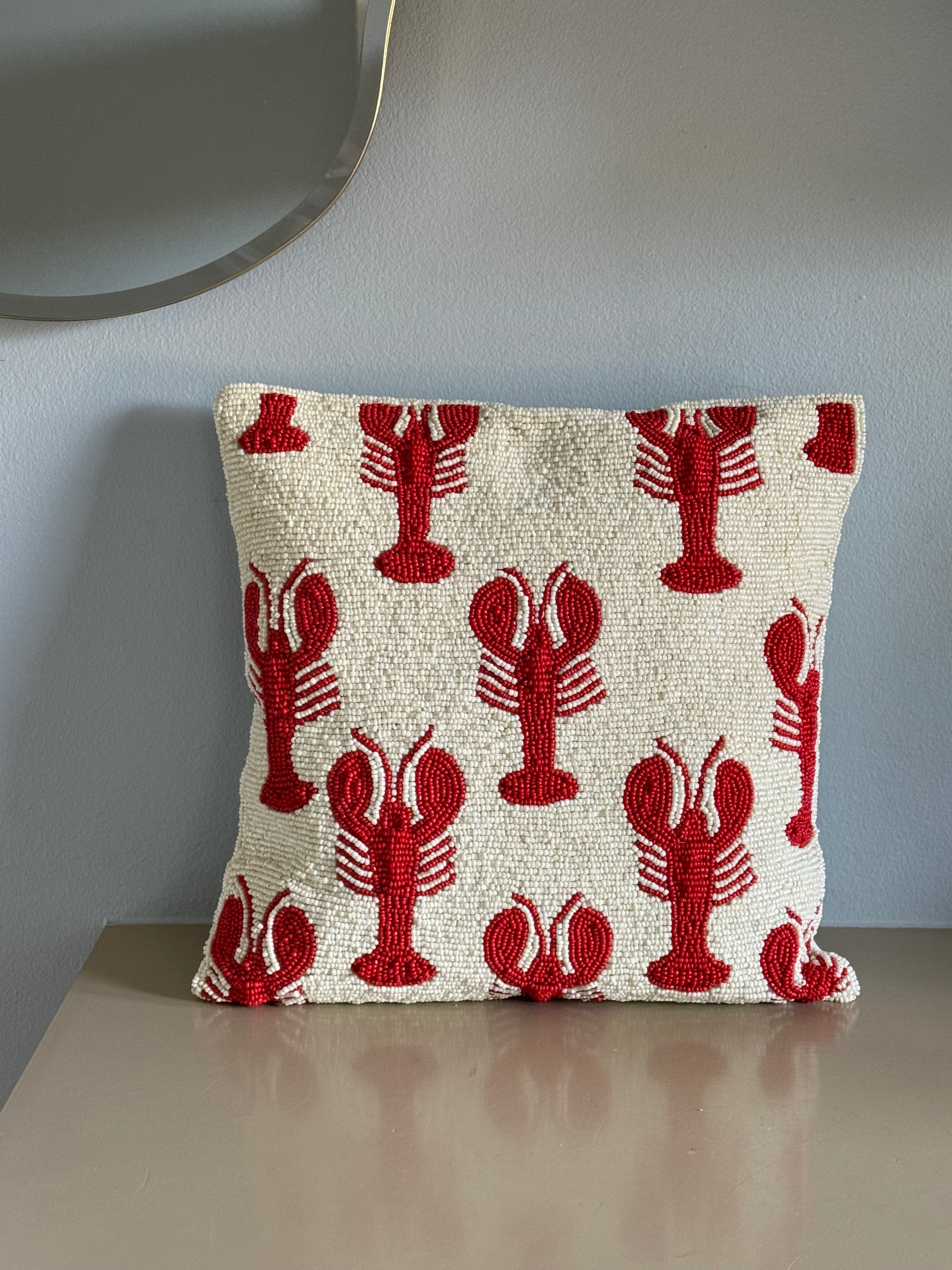 Decorative cushion cover in white with red lobster pattern, handcrafted detail for sofa or armchair.