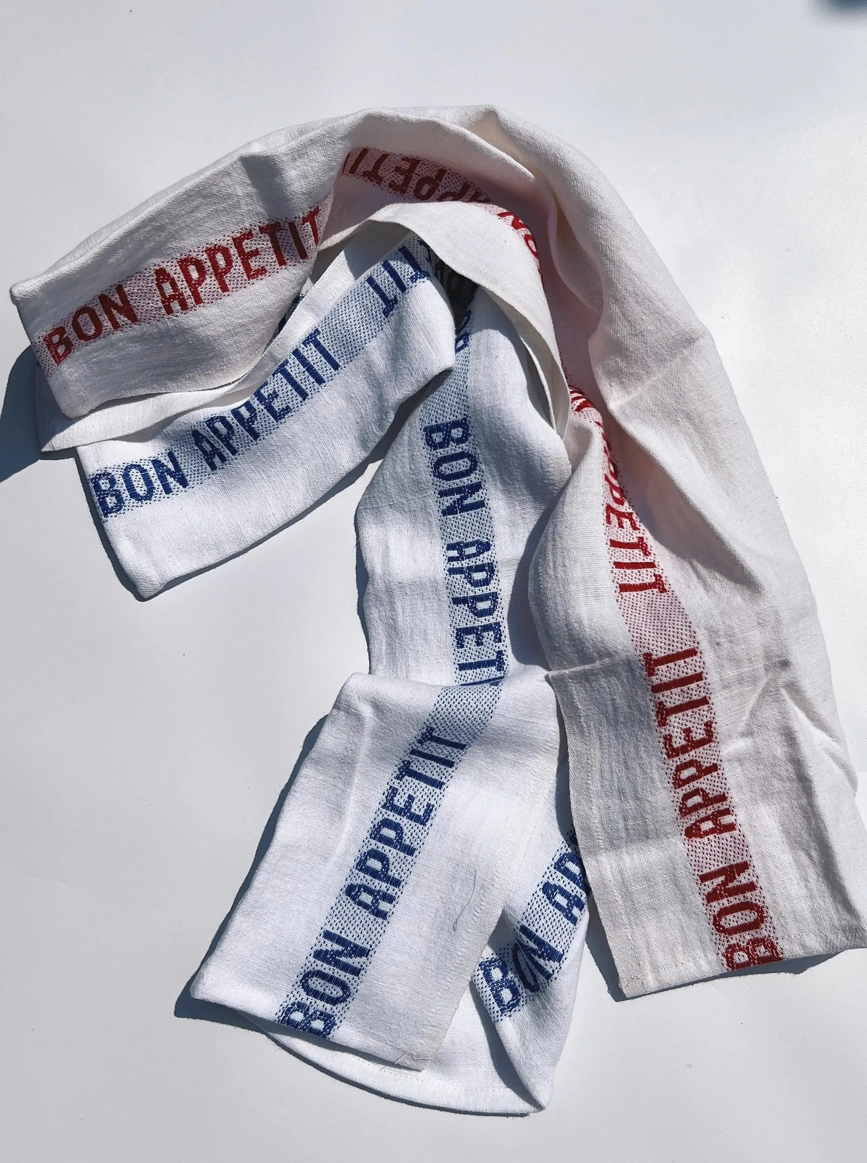 Charvet Editions tea towel in white with blue and red Bon Appetit text – classic French kitchen textile.