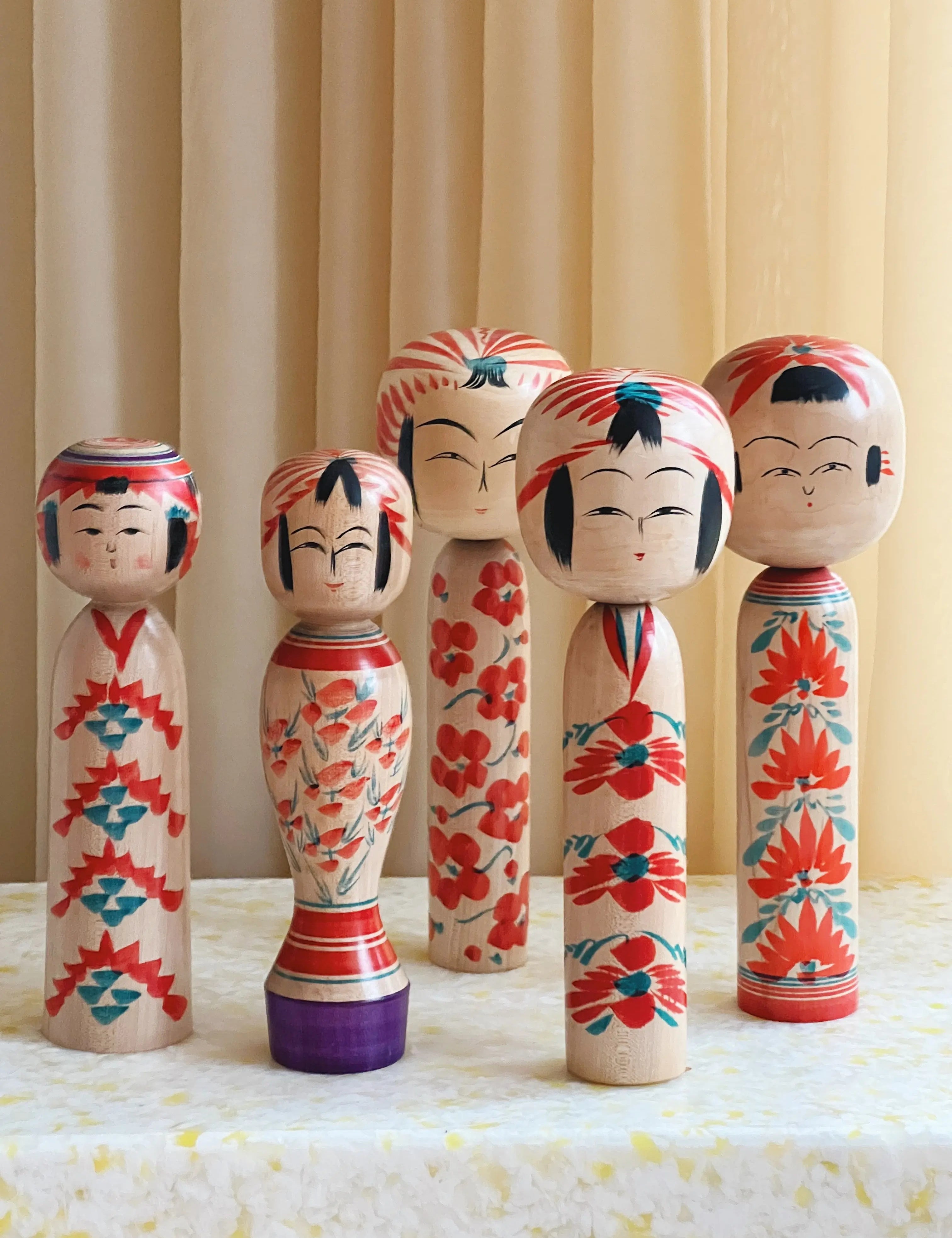 Collection of vintage Japanese Kokeshi dolls in different sizes and designs – traditional handcrafted wooden dolls symbolizing culture and artistry.