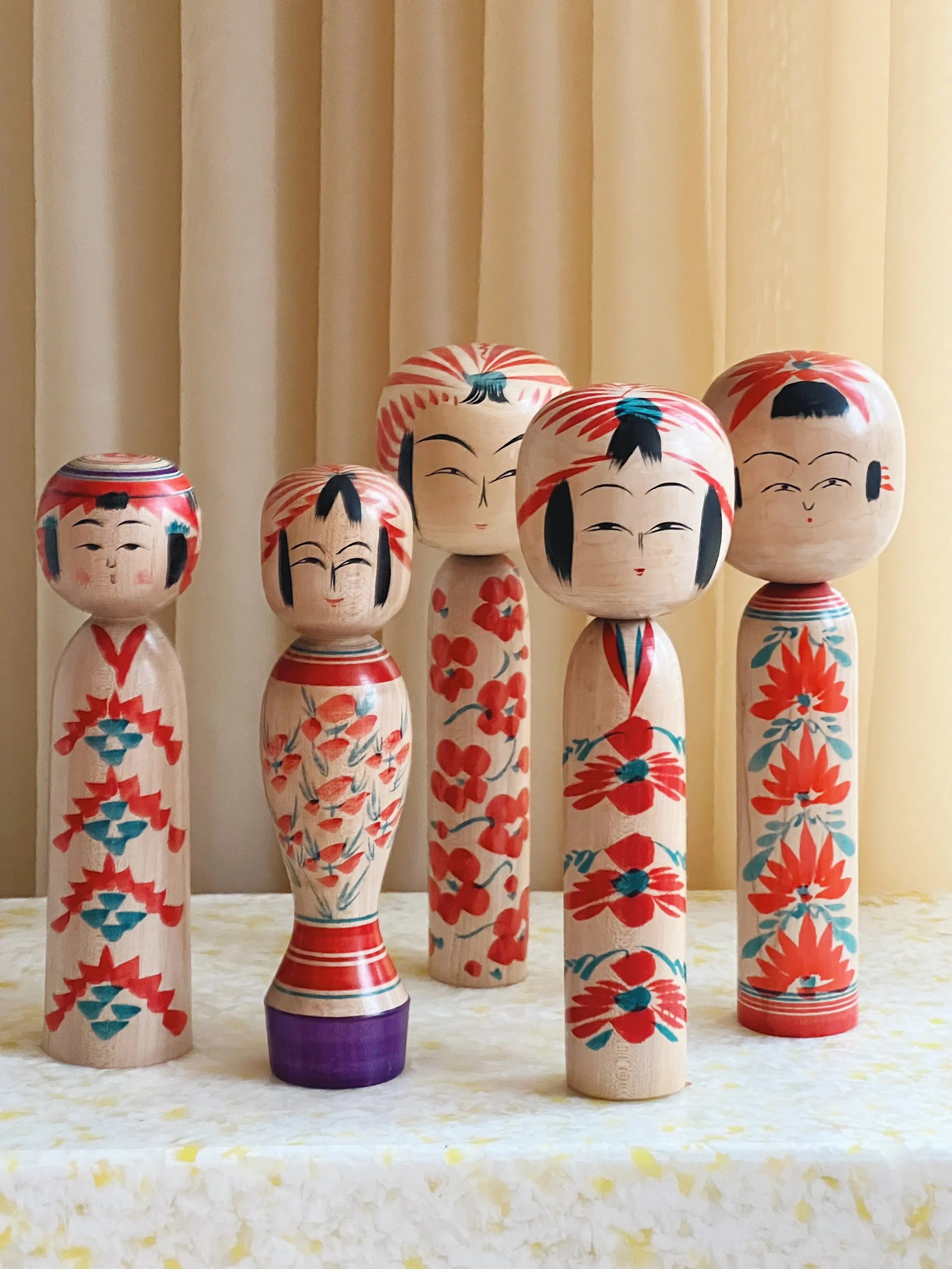 Collection of vintage Japanese Kokeshi dolls in different sizes and designs – traditional handcrafted wooden dolls symbolizing culture and artistry.