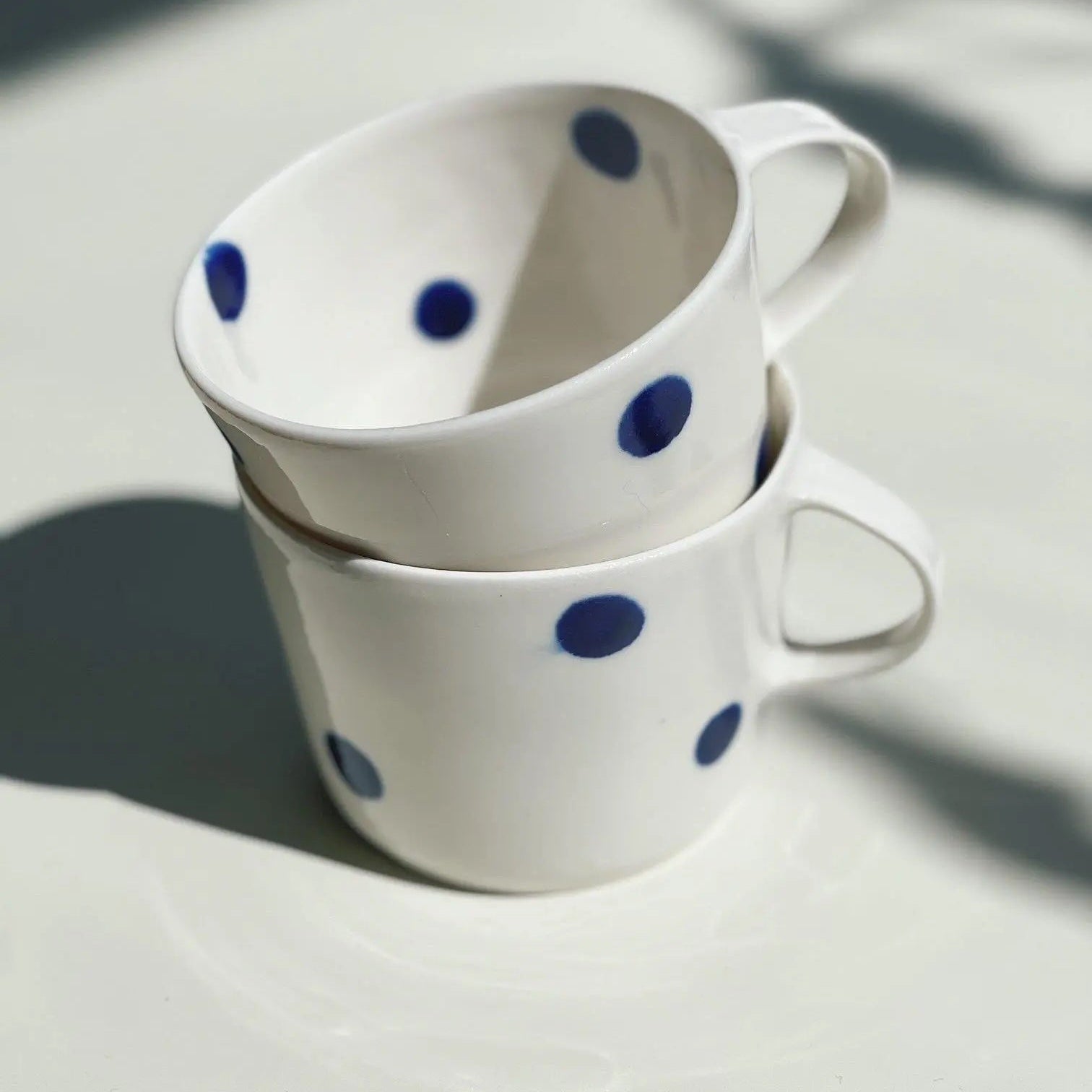 Handmade ceramic coffee cup with blue dot pattern by Ann-Louise Roman, Stockholm – Studio Hafnia