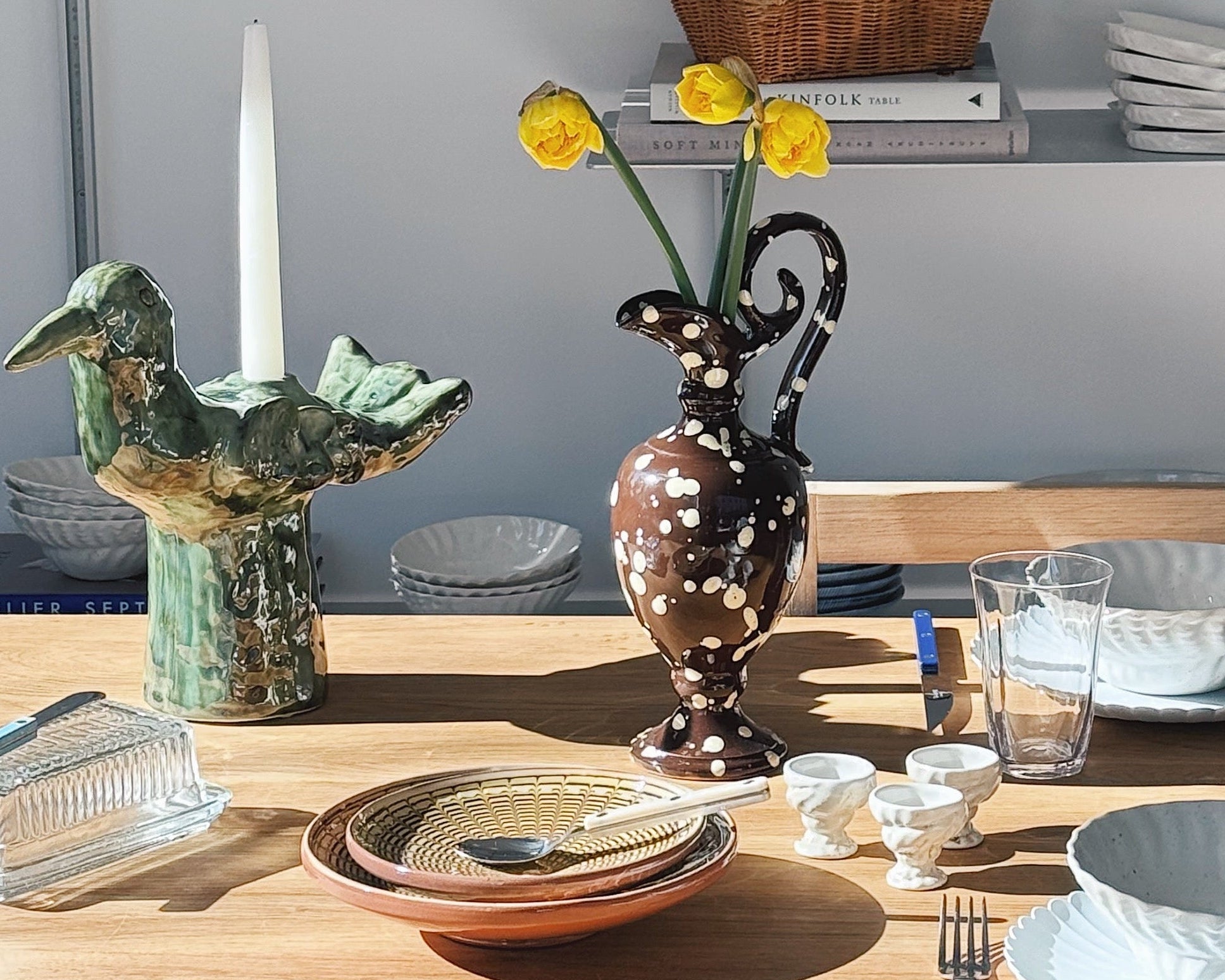 Påskebord med keramik, glas og naturlig borddækning i forårslys