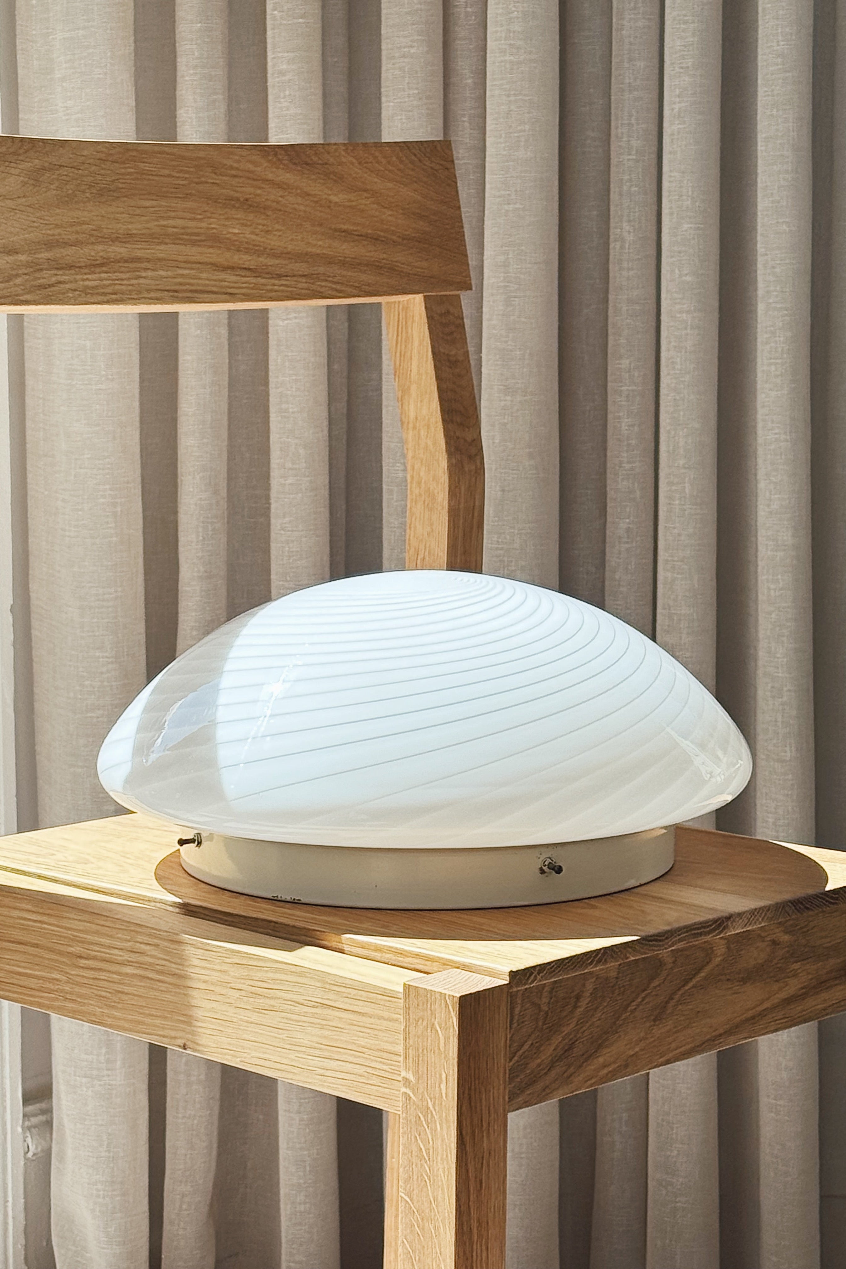 Vintage Murano plafond ceiling lamp in white swirl glass on a wooden chair, seen from the side, Ø32 cm