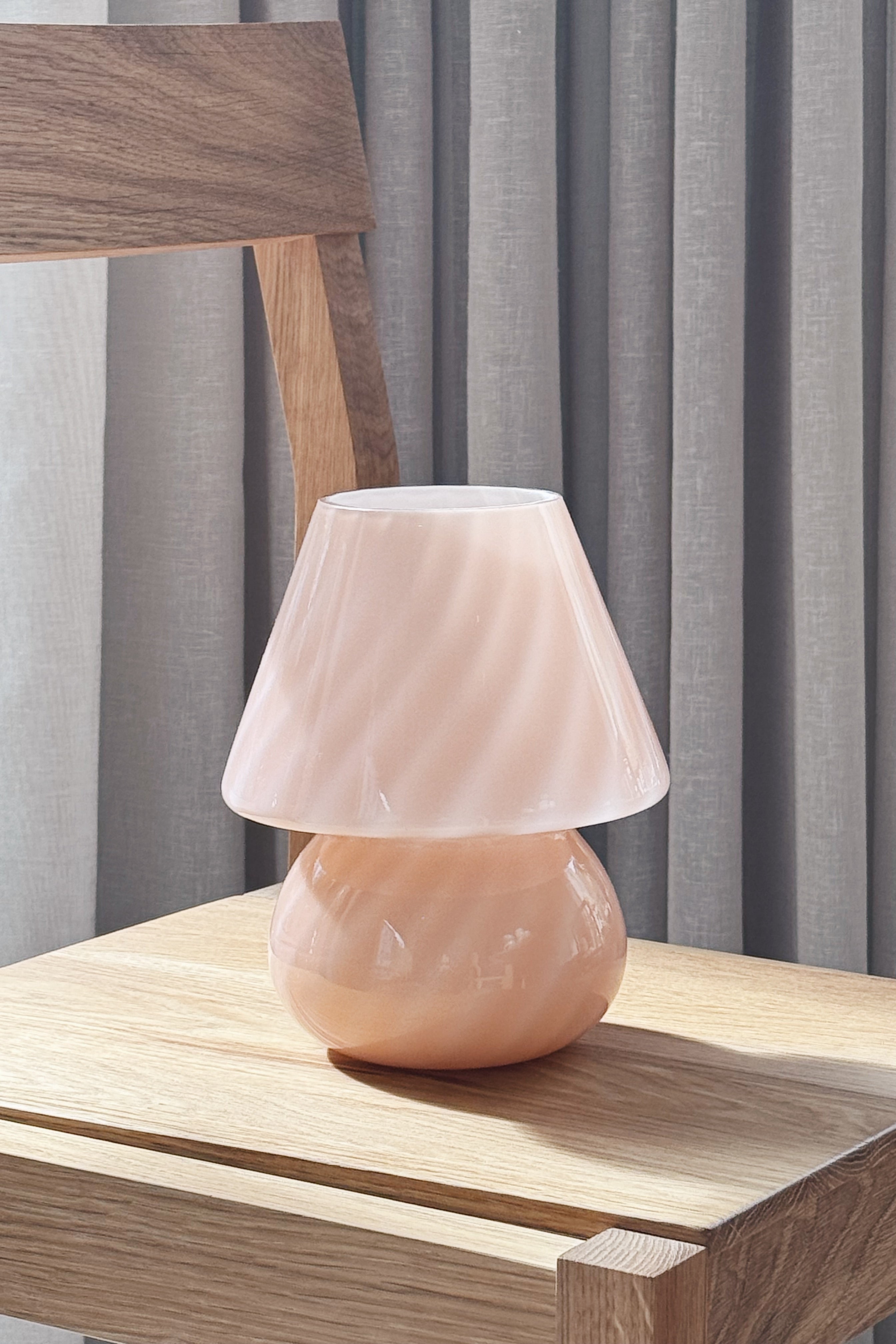 Vintage Murano baby mushroom table lamp in pink swirl glass, H20 cm, on an oak chair