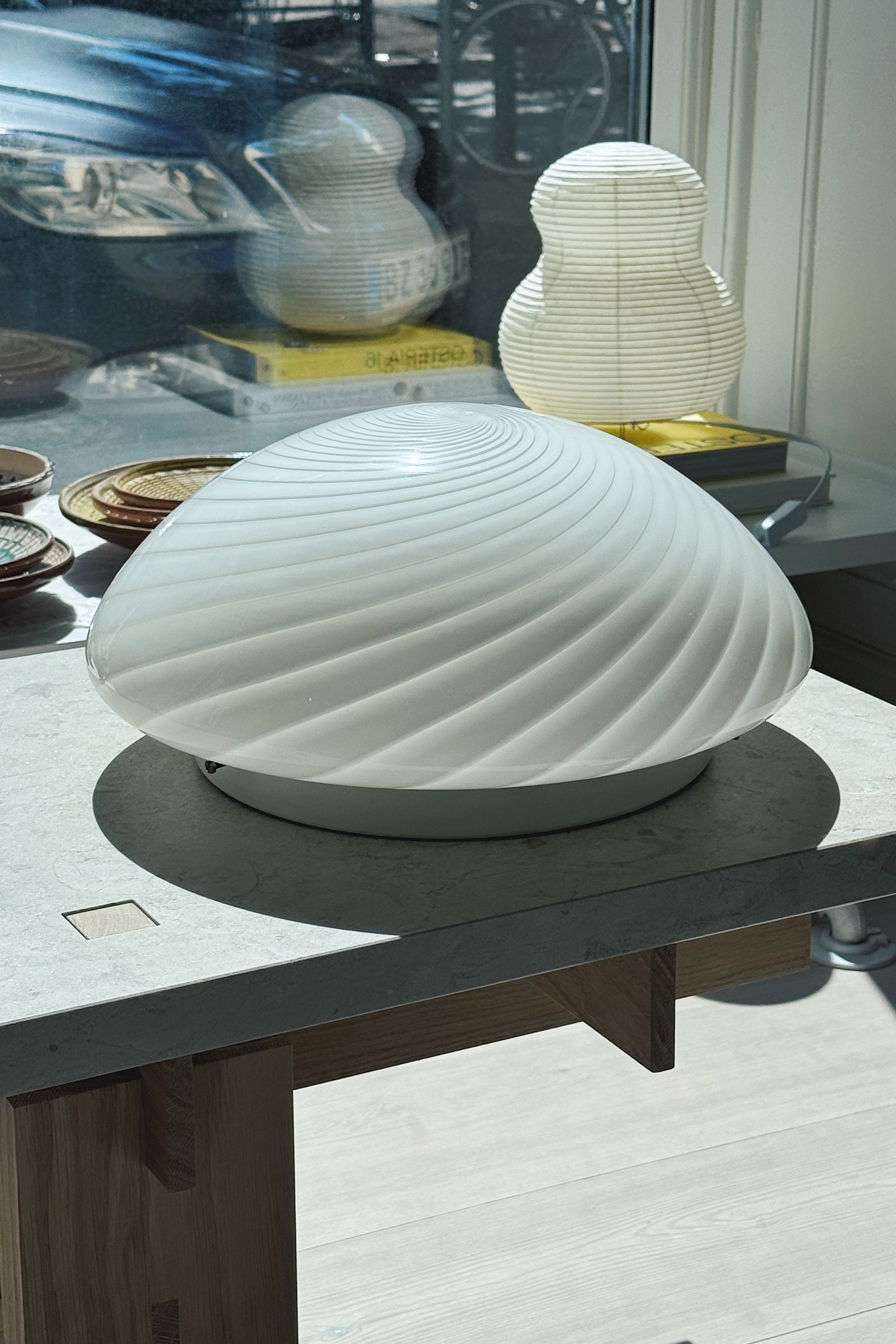 White Murano swirl plafond lamp Ø34 cm styled on a table in an interior