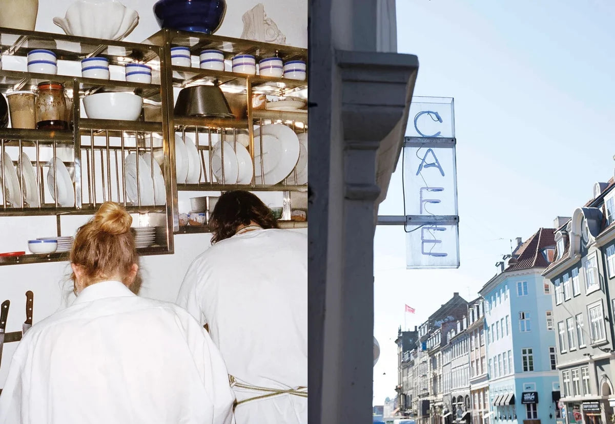 Two staff in white behind the crockery shelf and a blue neon CAFE sign above a Copenhagen street