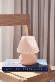 Small pink Murano mushroom lamp in mouth-blown glass resting on a book