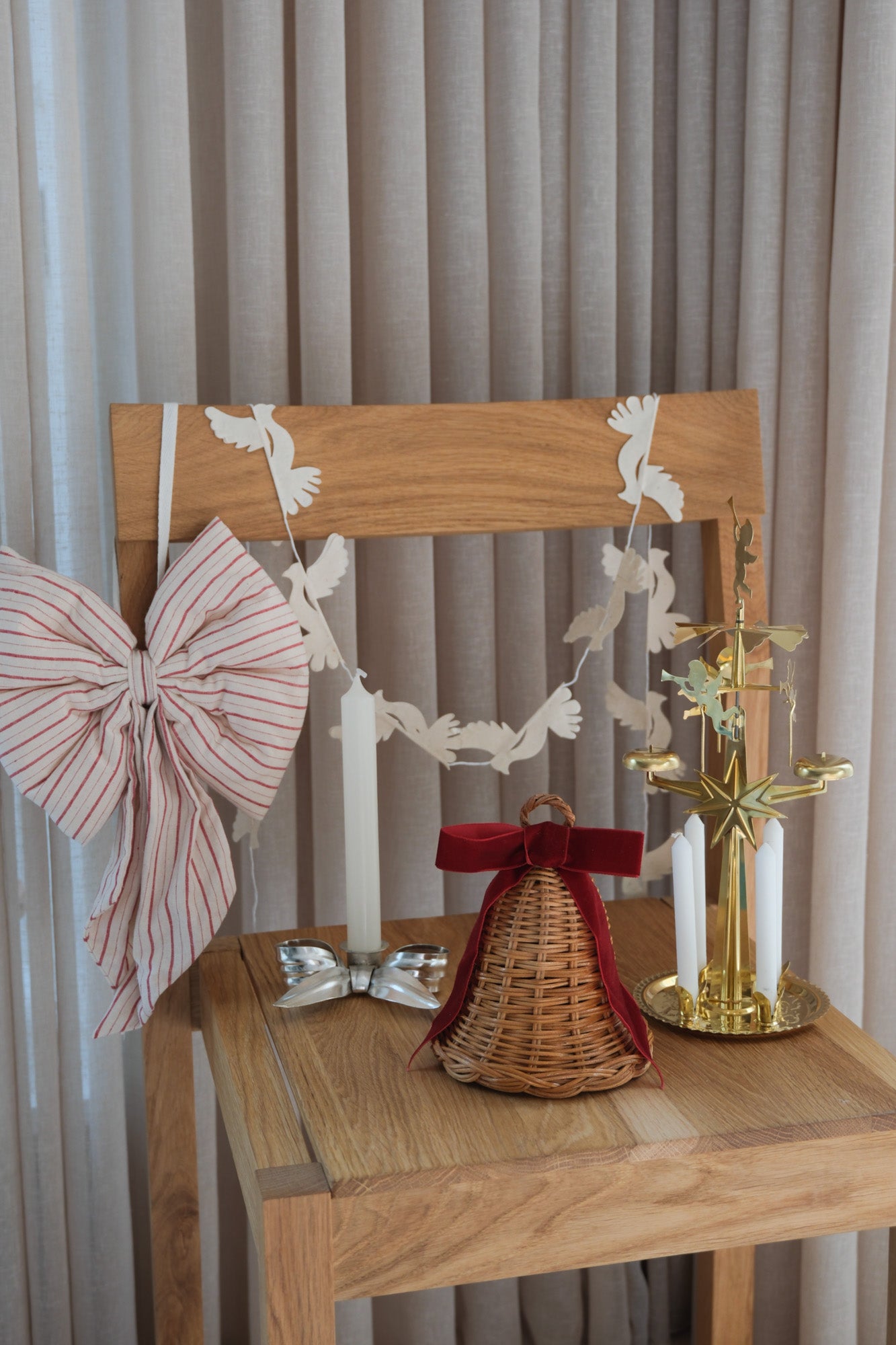 Studio Hafnia Christmas package with rattan Christmas bell, striped Christmas bow, silver candlestick, brass angel chime and paper dove garland