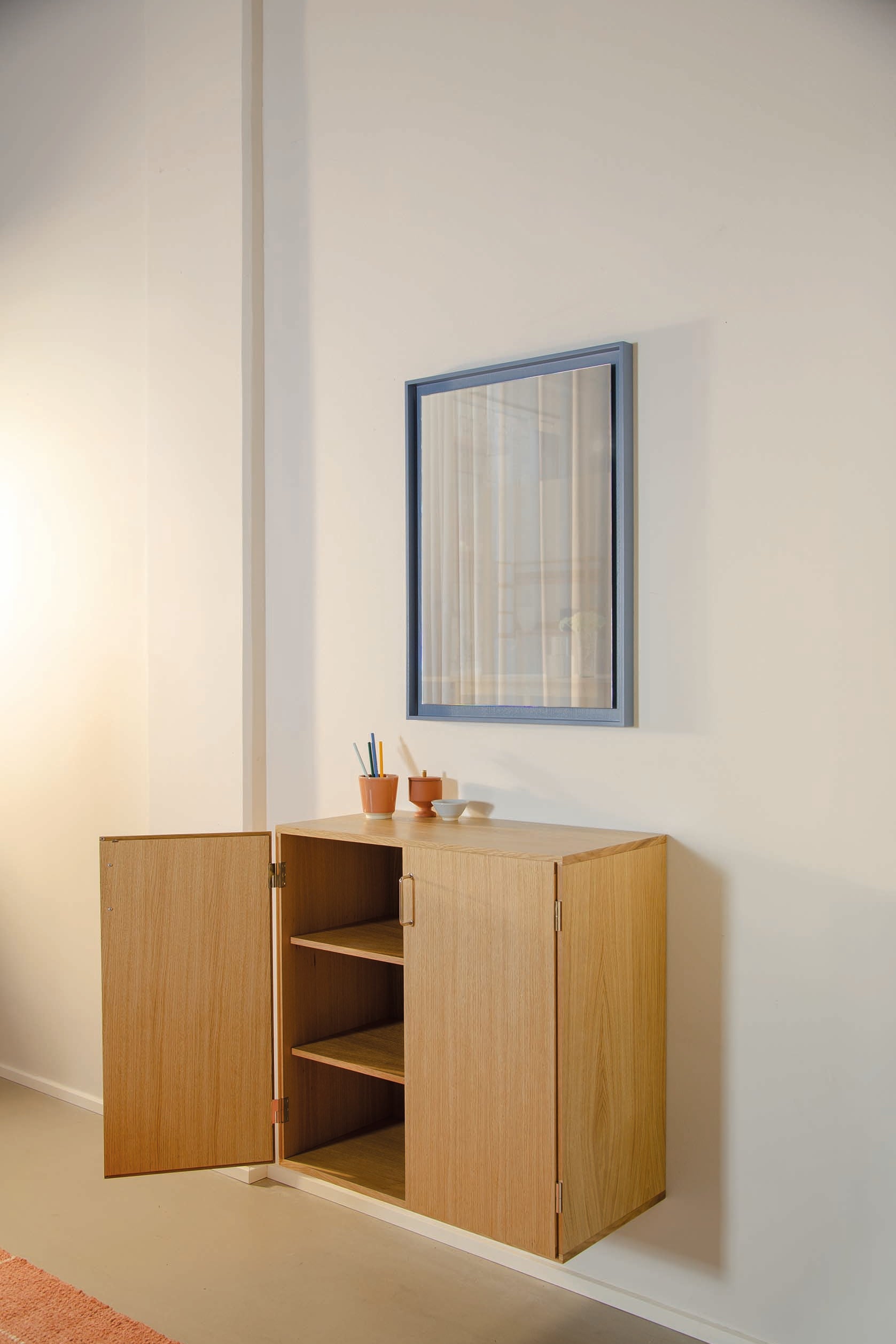 Stillark Relief Mirror in Misty Blue hung in a hallway, Studio Hafnia