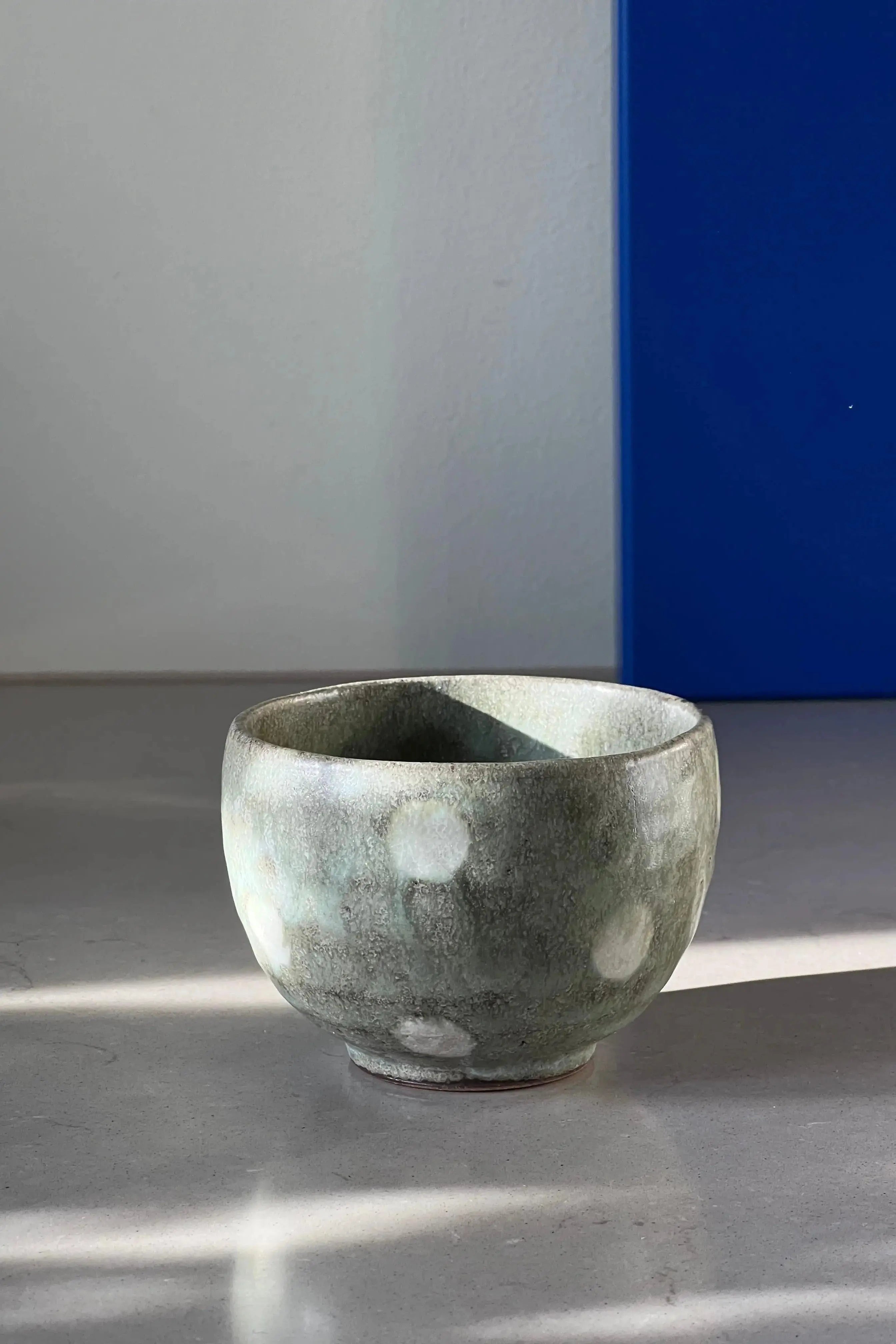 Håndlavet lysegrå /lysegrøn kop med hvide prikker uden hank fra Japan i keramik Studio Hafnia