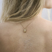 Close-up of the sculptural pendant on the Inger necklace in 14 carat gold against the skin