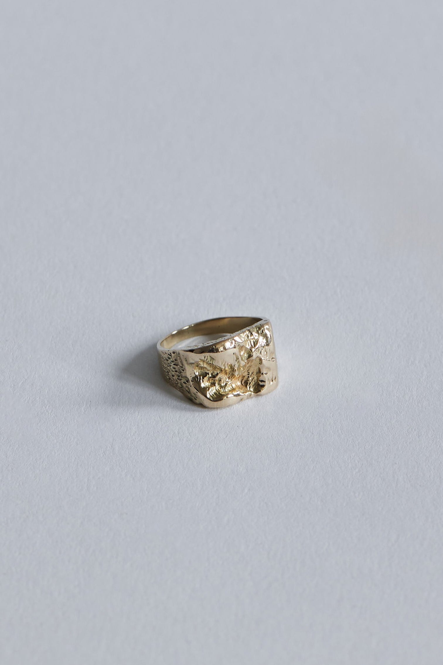 Inger Ring i 14 karat guld set tæt på, hvor de organiske fordybninger fanger lyset