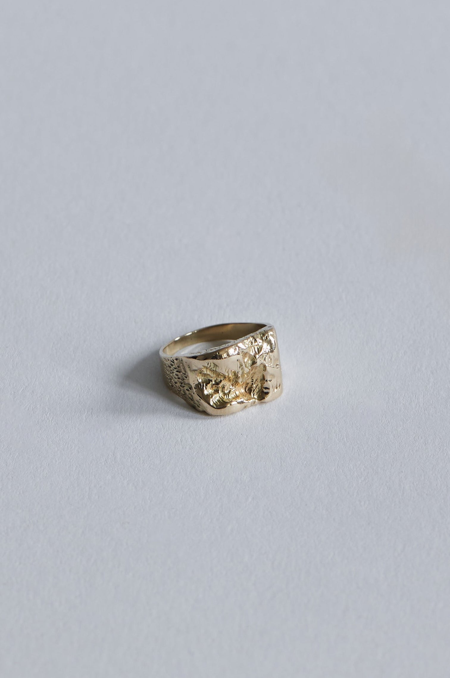 Inger Ring i 14 karat guld set tæt på, hvor de organiske fordybninger fanger lyset