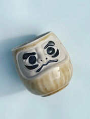 Japansk Daruma krus i sand/gylden gul keramik Studio Hafnia