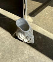 Conch Jug in cream ceramic from Christina Iversen Studio in strong sunlight on a concrete floor