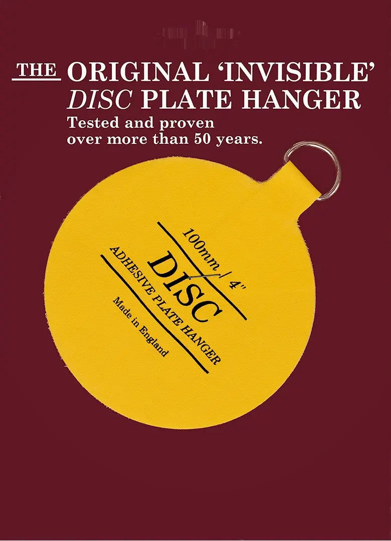Invisible plate hanger, yellow 100 mm disc with metal ring, fitted to the back of a plate with a blue pattern