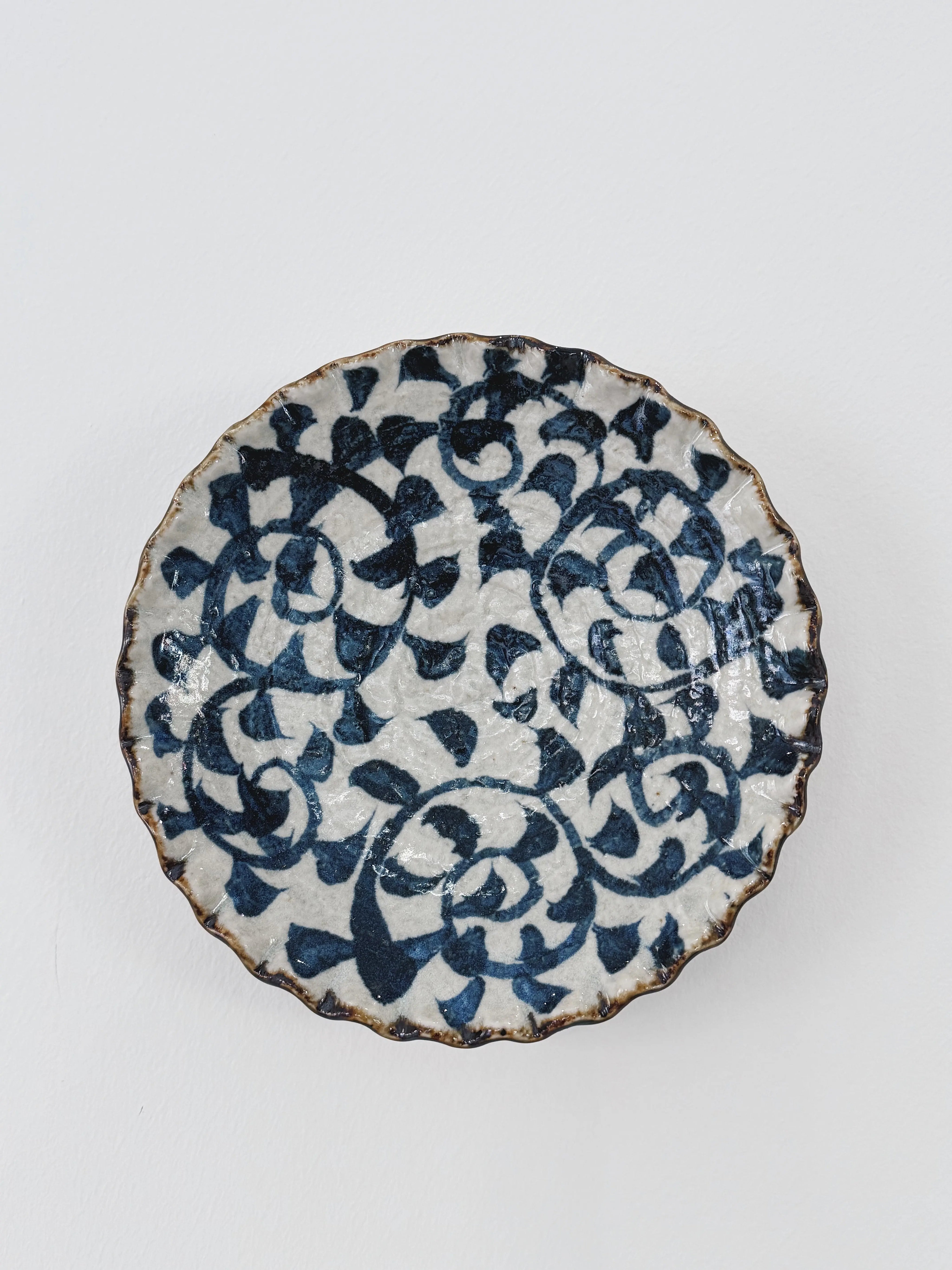 White plate with hand-painted blue pattern, seen from the front