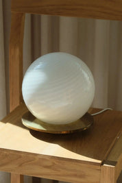 White Murano swirl table lamp with a round brass-coloured metal base from Studio Hafnia