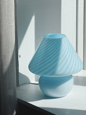 Close-up of the light blue Murano mushroom lamp's swirl pattern and dome shape in backlight