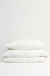 White Aiayu seersucker duvet cover and pillowcase folded in a stack, Studio Hafnia
