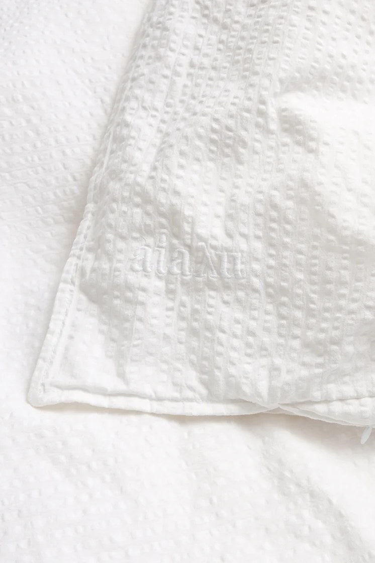 Close-up of the crinkled seersucker weave with the embroidered aiayu logo, white, Studio Hafnia