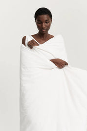 Woman wrapped in the Aiayu seersucker duvet cover in white organic cotton, Studio Hafnia