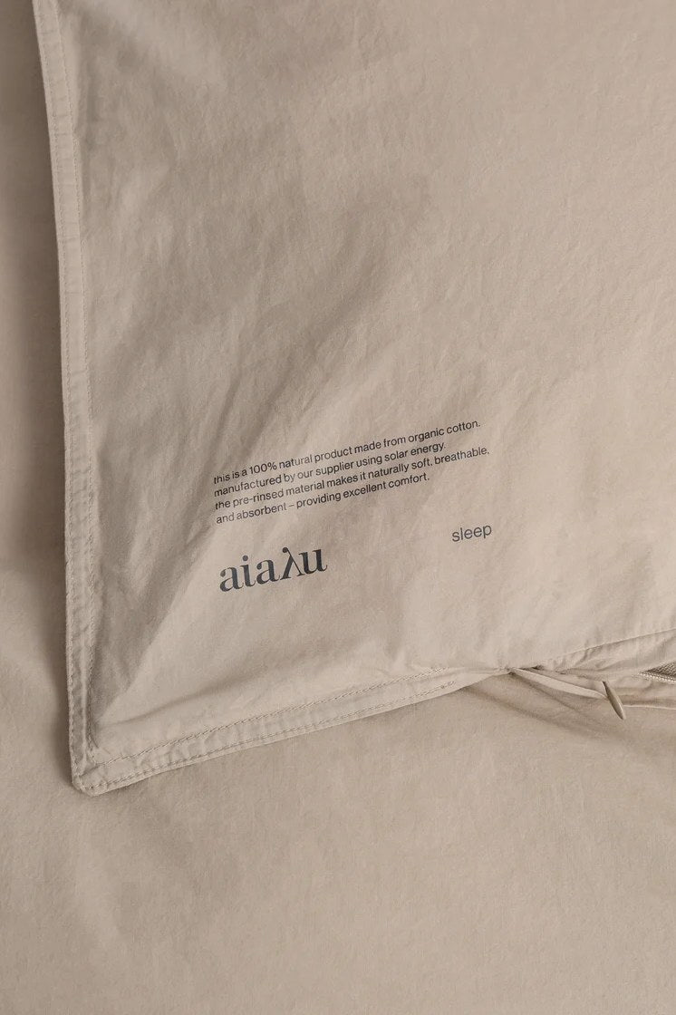 Nærbillede af hjørne og vaskemærke på Aiayu dynebetræk i farven Dried Herb, Studio Hafnia