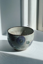 Japanese porcelain cup without a handle in cream crackle glaze with purple camellia flowers, green leaves and a dark brown rim, 310 ml