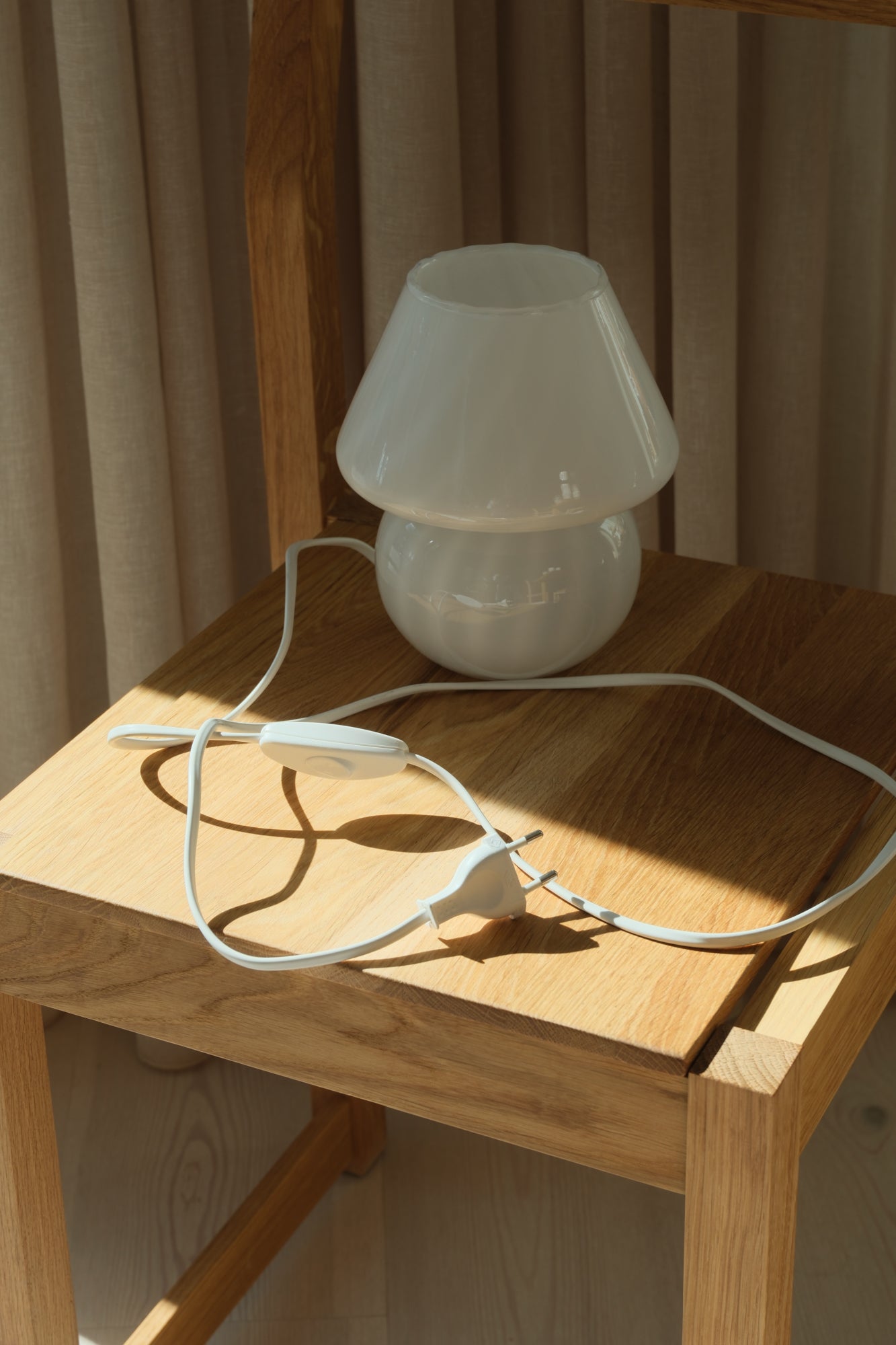 Small white Murano mushroom table lamp with rounded base and wide shade from Studio Hafnia
