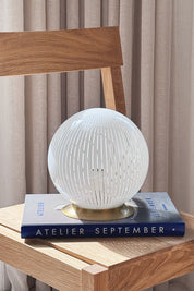 Vintage Murano filigrana globe table lamp in white glass with brass base, H20 cm, styled on a book on an oak chair