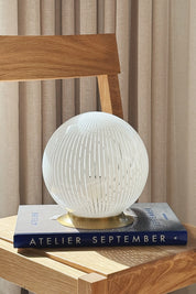 White Murano globe table lamp H20 cm styled in daylight on an oak chair with a book