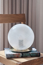 Vintage Murano globe table lamp in white swirl glass with brass base, H25 cm, standing on books on an oak chair
