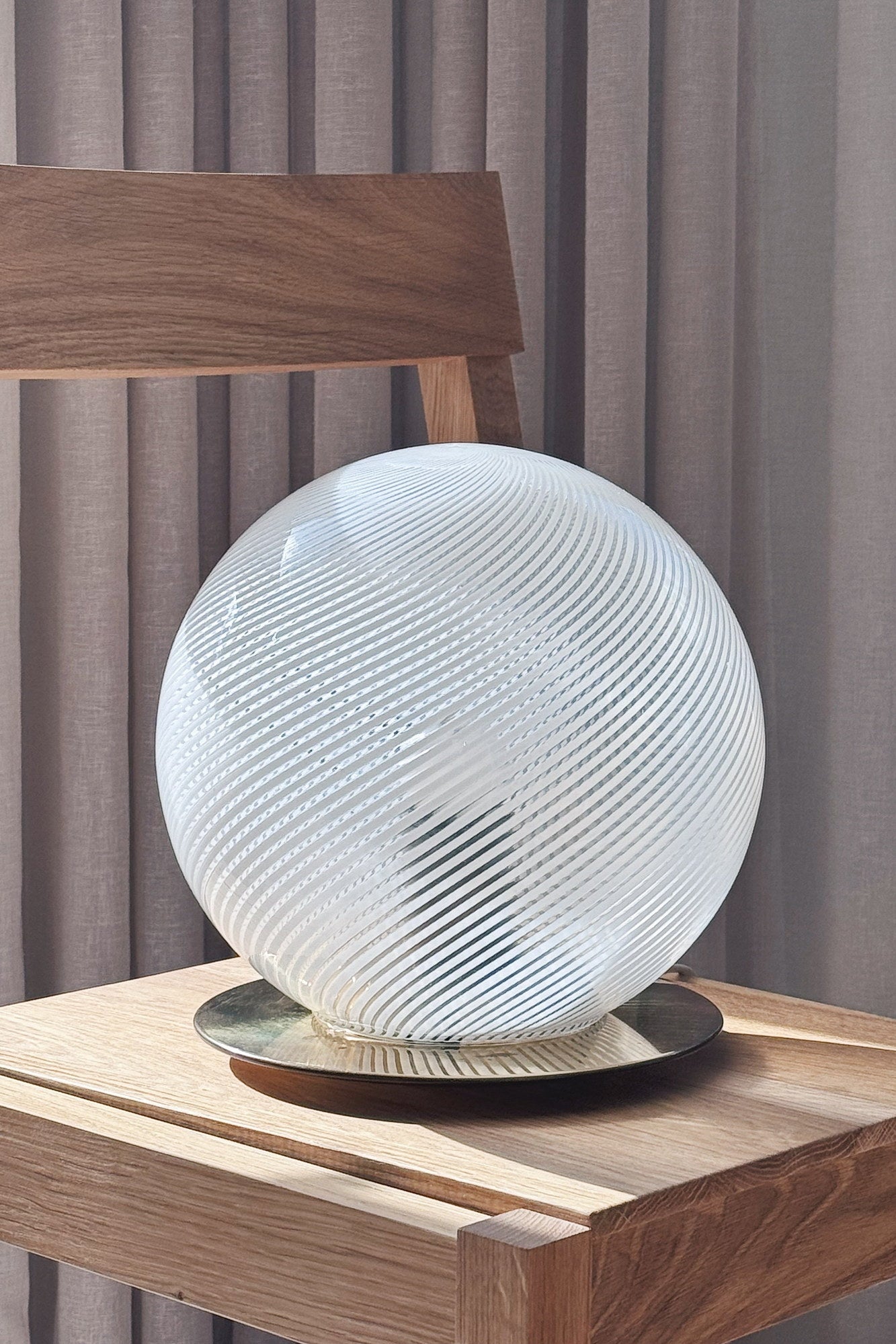 Close-up of the white Murano globe lamp's spiralled glass and round polished brass base