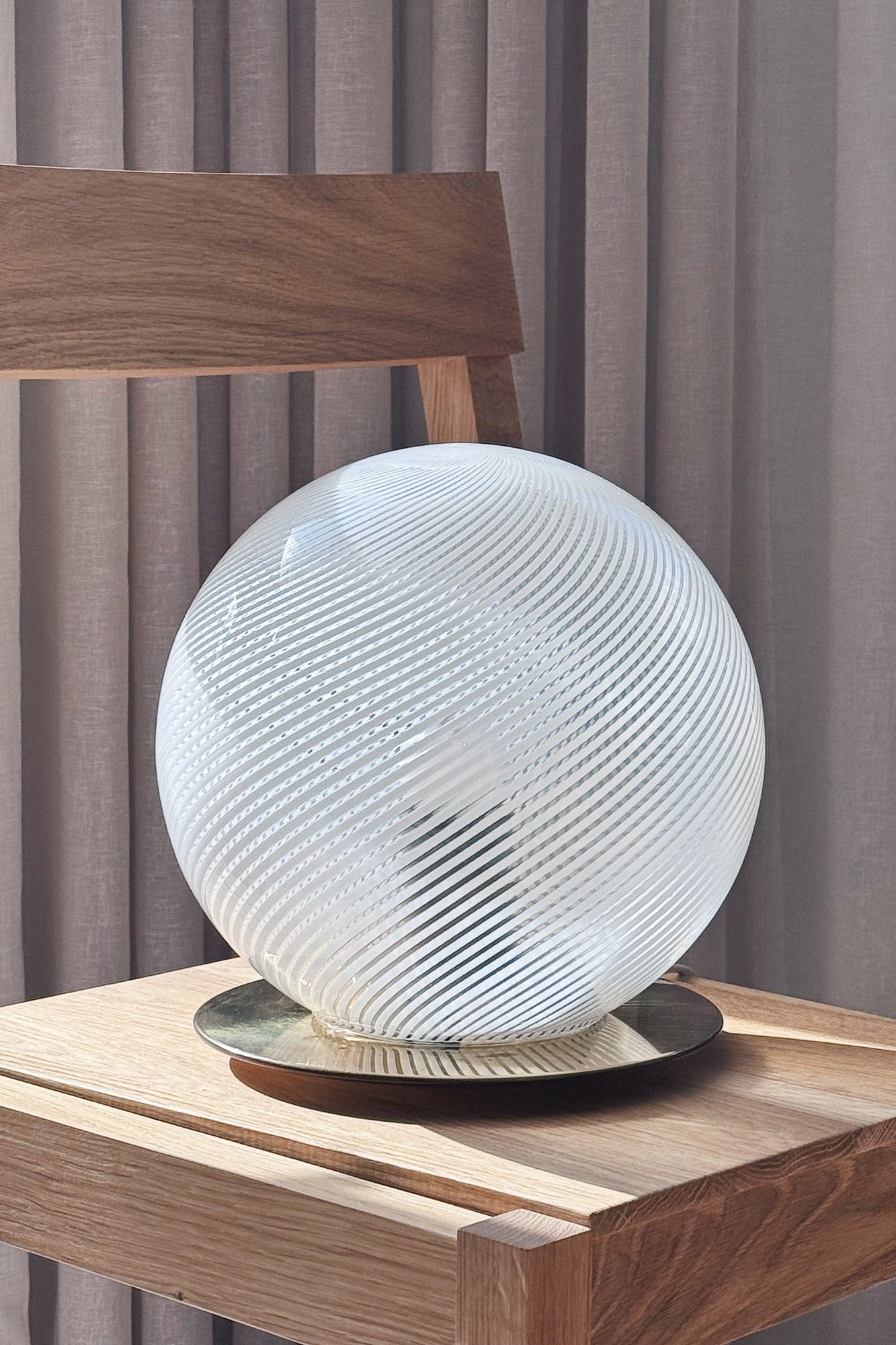 Close-up of the white Murano globe lamp's spiralled glass and round polished brass base
