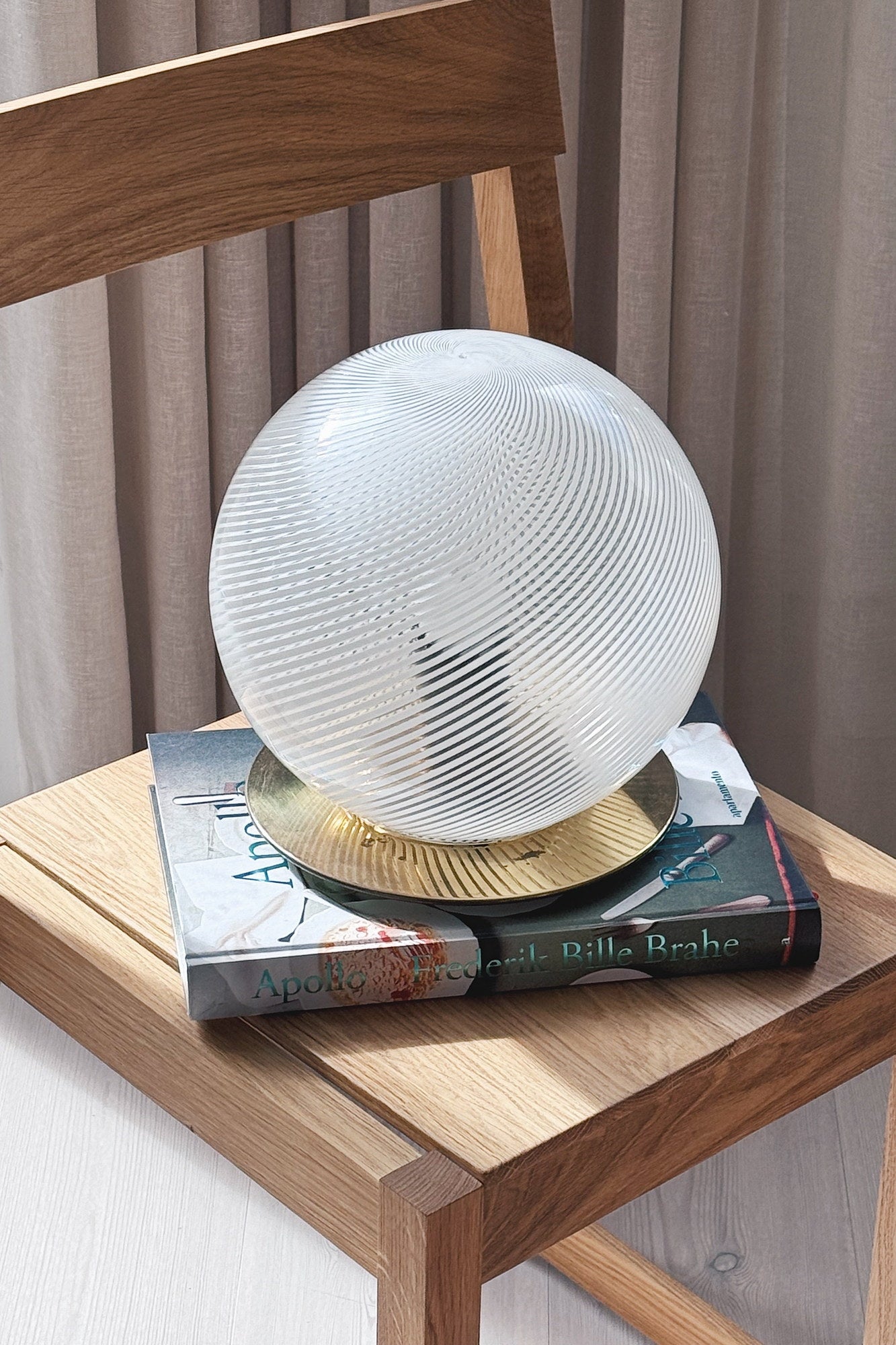 Large Murano globe lamp seen from above with its golden brass base and white spiral glass