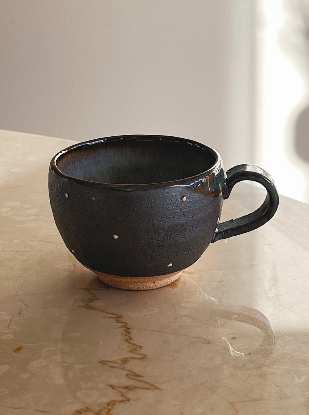 Håndlavet brun/mørkegrå kop med små hvide prikker med hank fra Japan i keramik Studio Hafnia