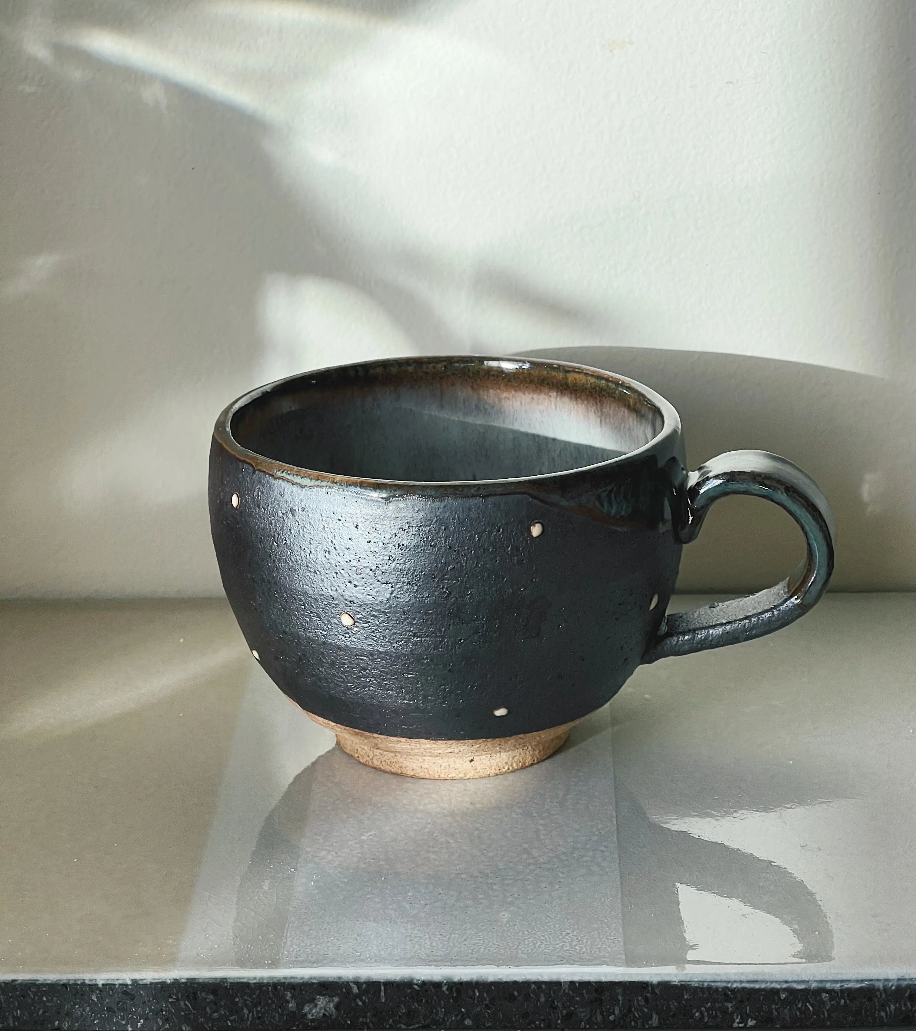 mørkegrå kop med små hvide prikker med hank fra Japan i keramik Studio Hafnia