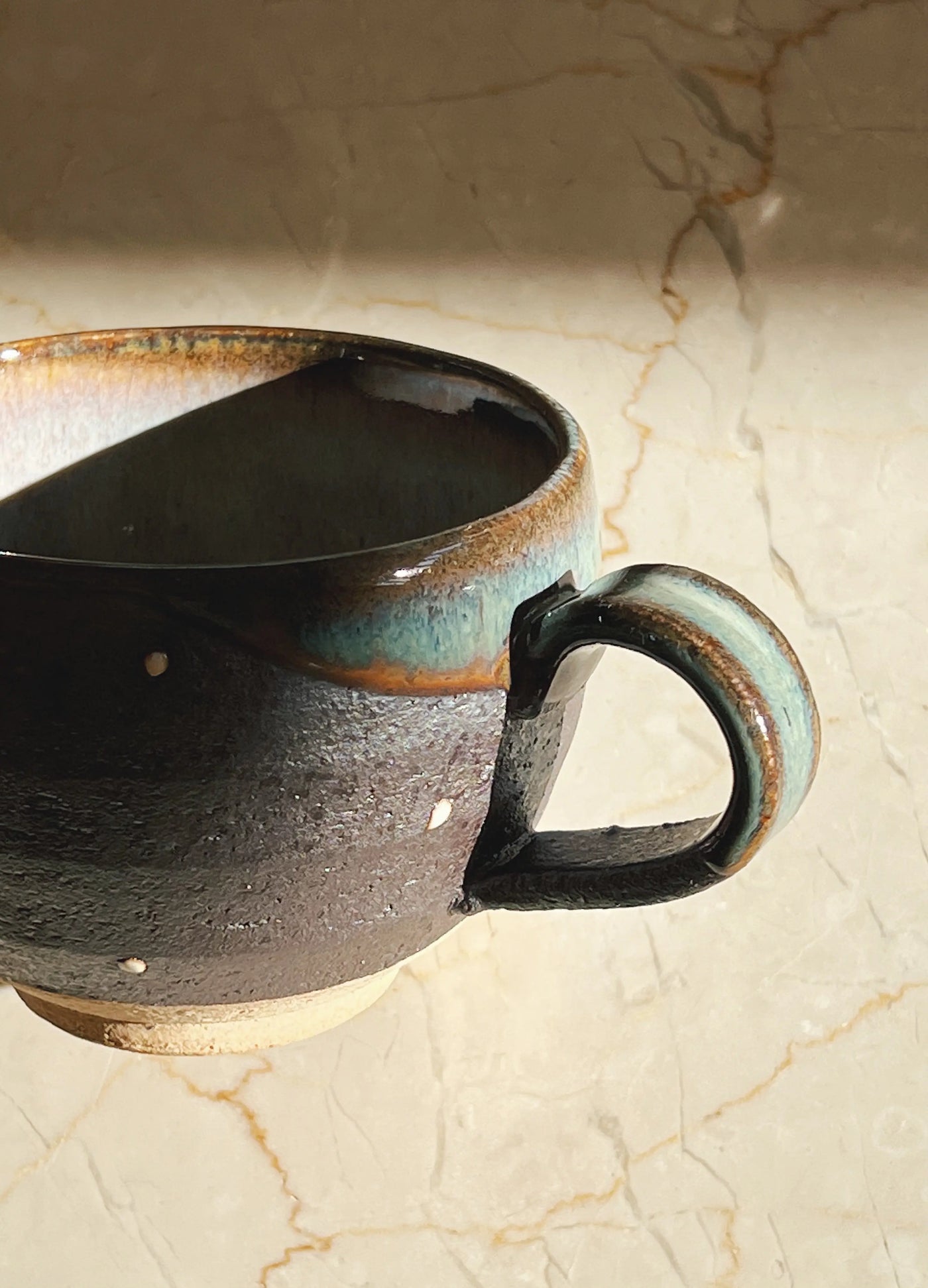 Håndlavet brun/mørkegrå kop med små hvide prikker med hank fra Japan i keramik Studio Hafnia