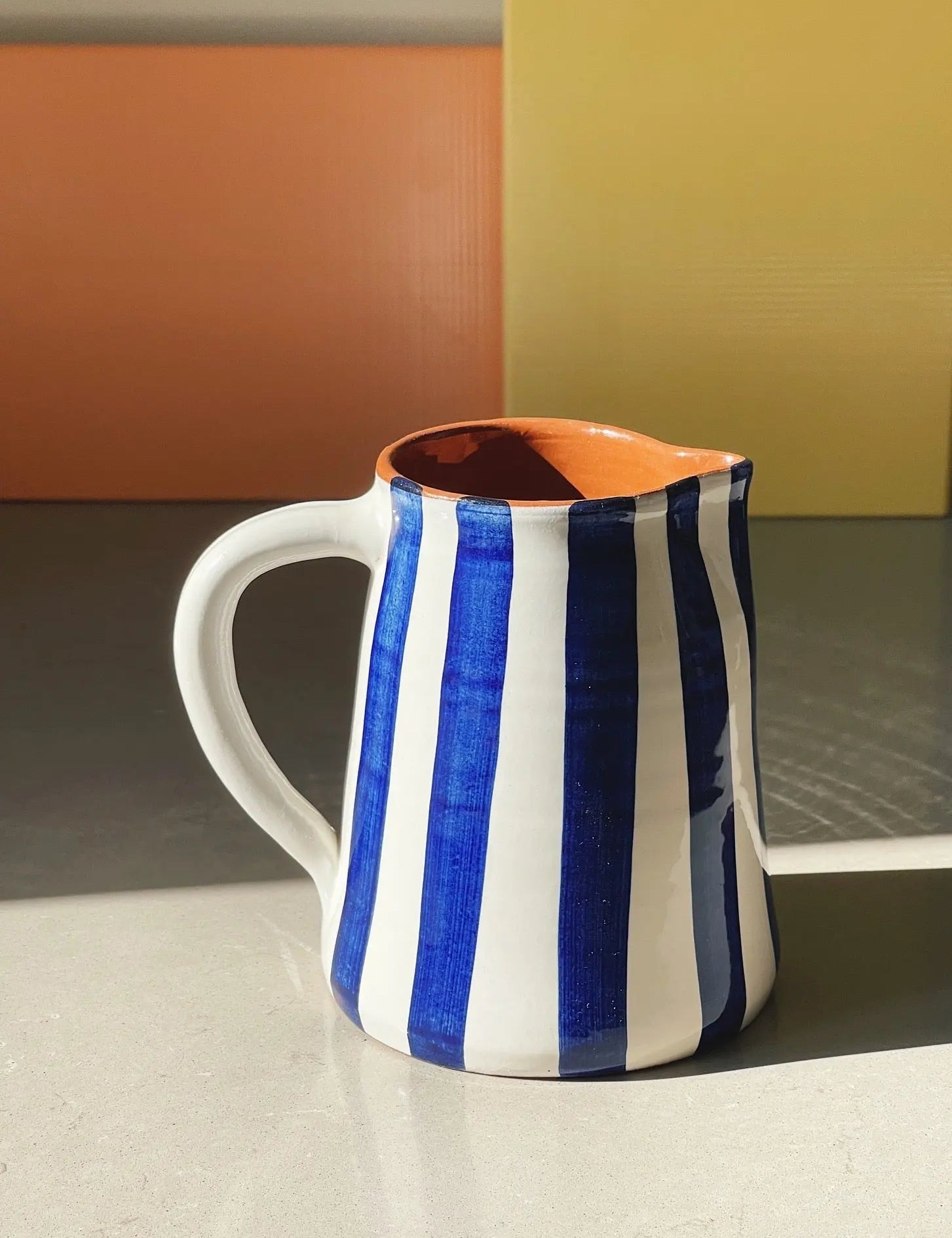 Håndlavet terracotta kande med blå og hvide striber Casa Cubista