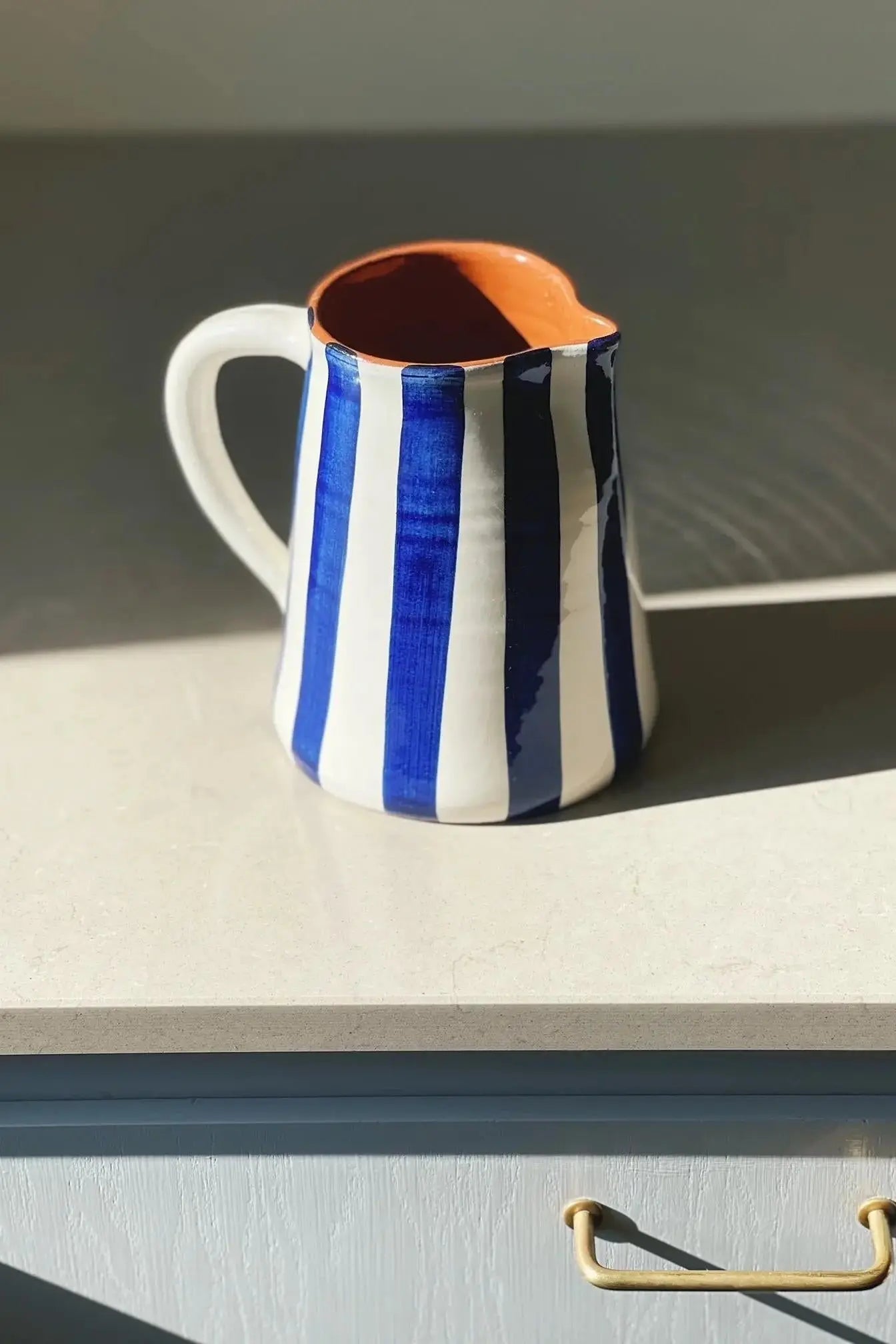 Håndlavet terracotta kande med blå og hvide striber Casa Cubista