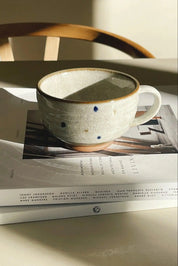 Japansk, sandfarvet krus i keramik med hank og blå og brune prikker Studio Hafnia